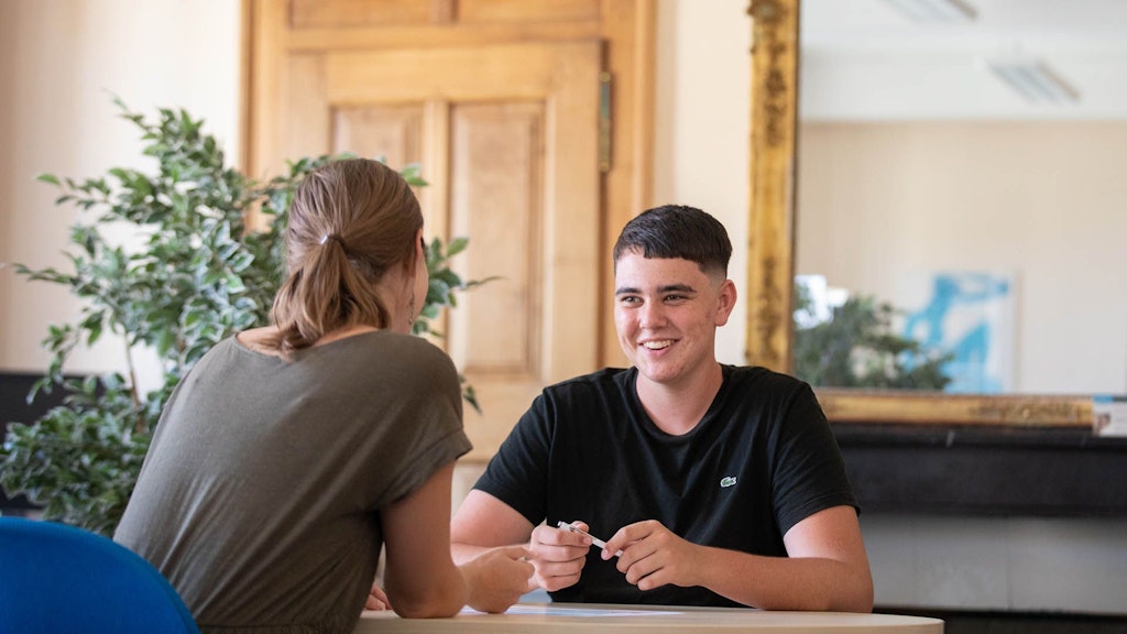 Beratungssituation im Berufsbildungszentrum Neuchâtel. Ein Jugendlicher im Gespräch mit einer Berufsberaterin.