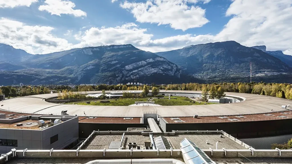 Installation de recherche circulaire avec des bâtiments au premier plan et des montagnes en arrière-plan.