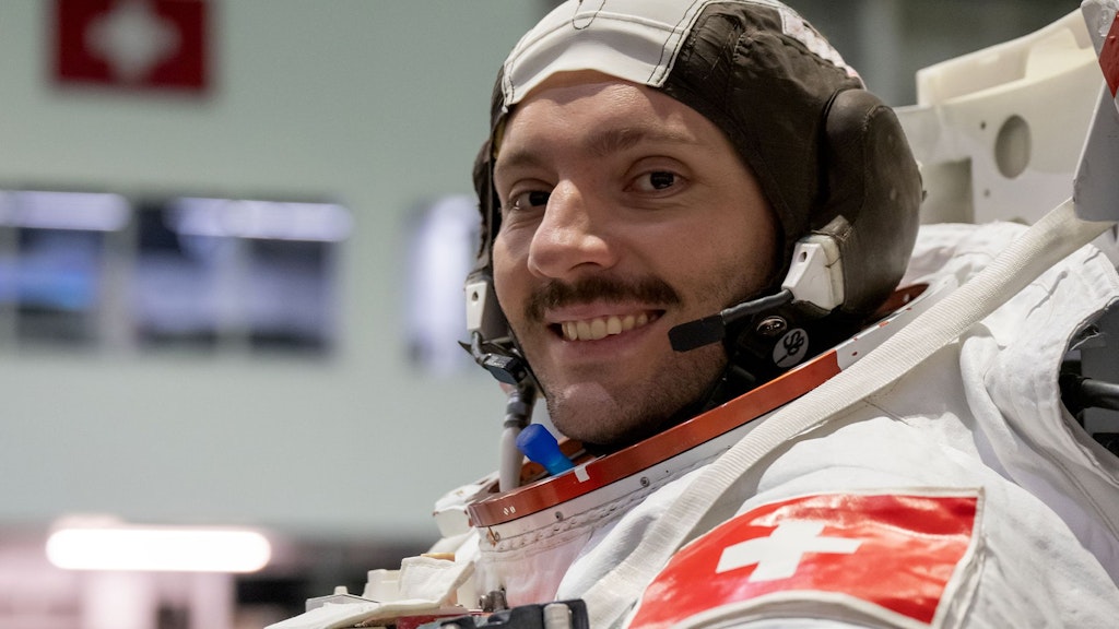Marco Sieber in tuta spaziale con una croce svizzera sulla spalla