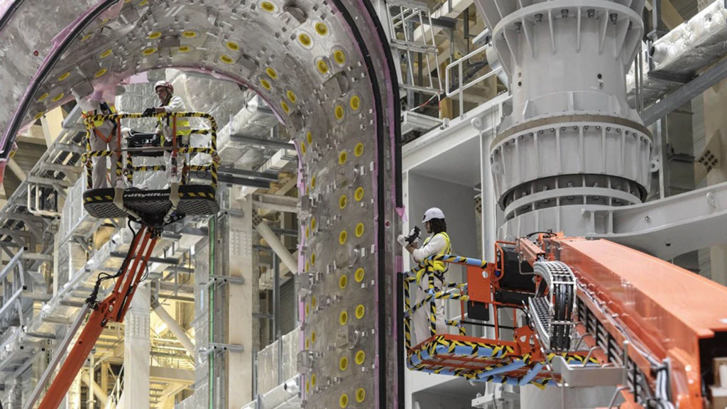 Tecnici specializzati assemblano un grande componente metallico in una struttura industriale moderna. La scena rappresenta l’ingegneria di precisione in un progetto tecnologico avanzato.
